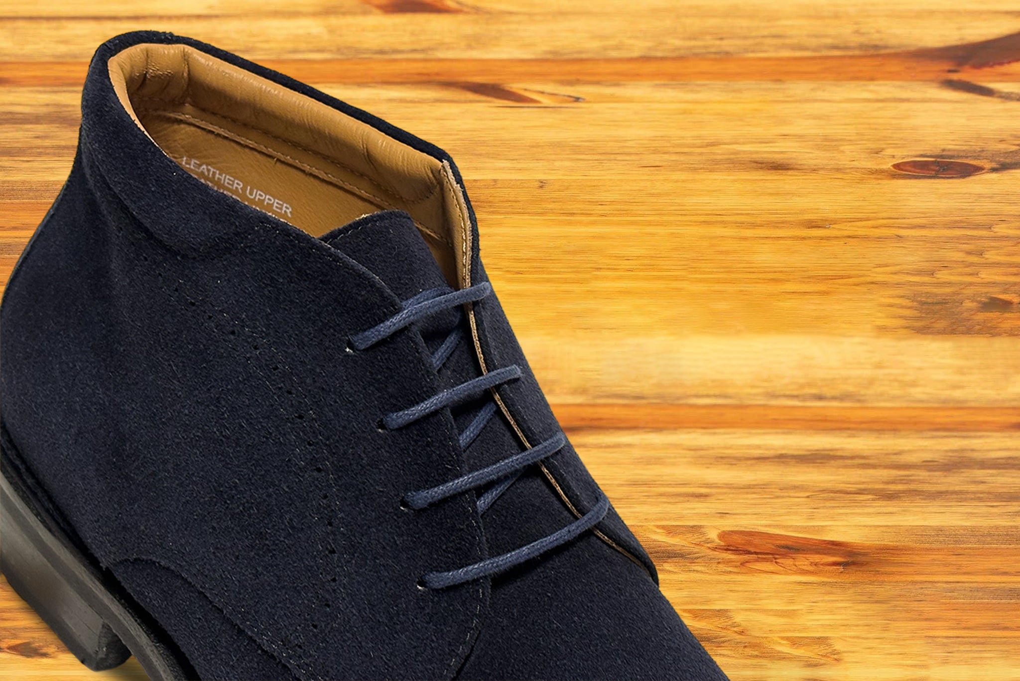 Navy blue suede shoes on a wooden surface