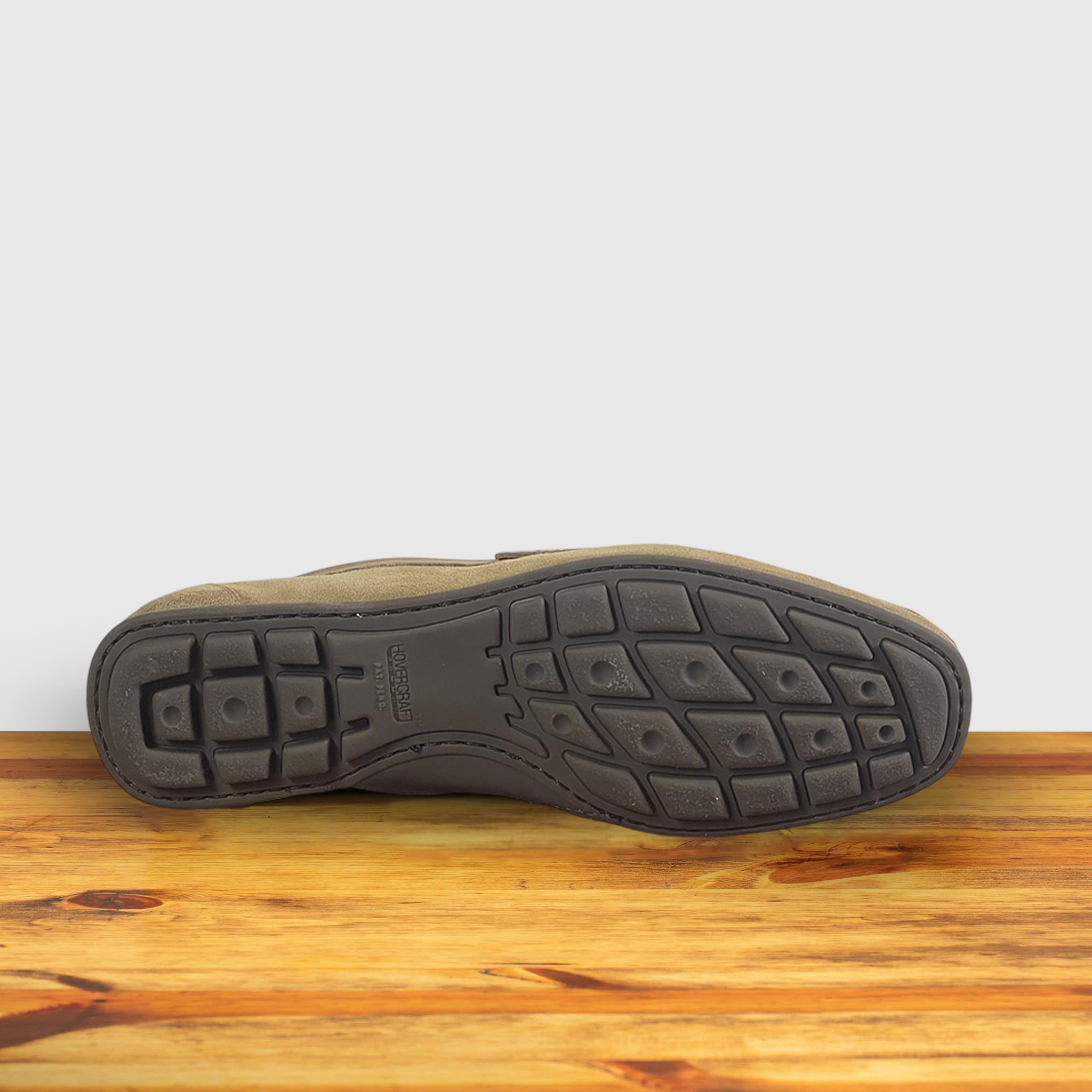 Back of Rope color suede penny loafer, displayed on a wooden surface.