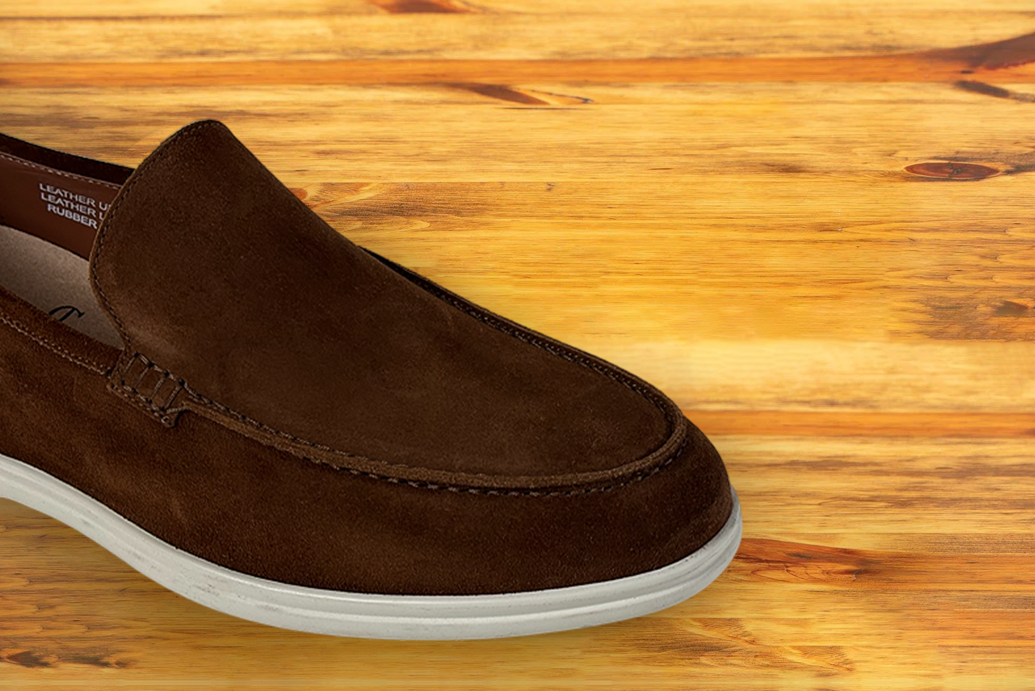 A Brick suede loafer shoe, displayed on a wooden surface.