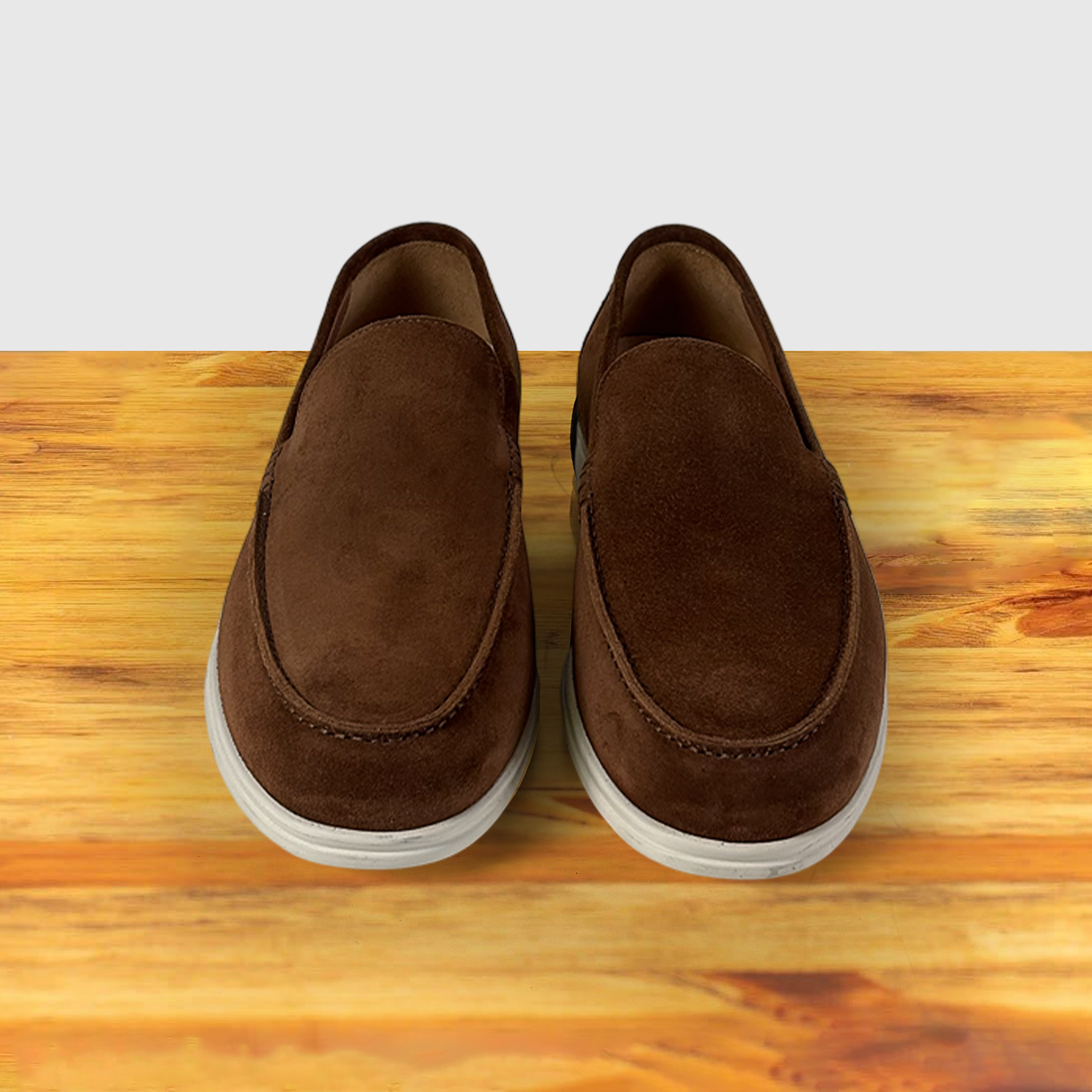 A Pair of Brick suede loafer shoe, displayed on a wooden surface.