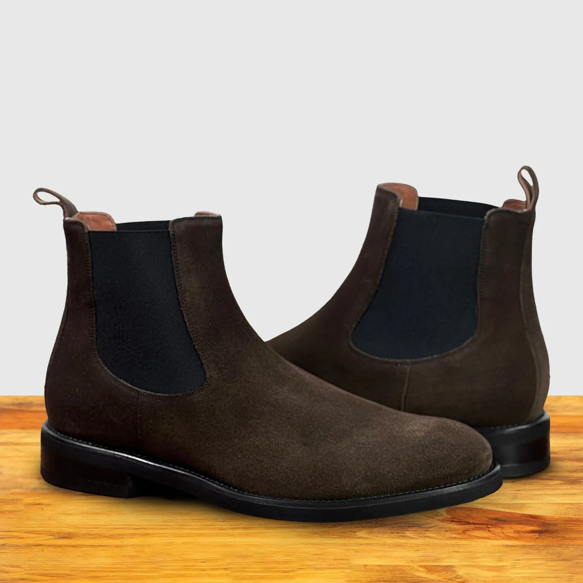 Dusty Brown suede Chelsea boot on a wooden surface