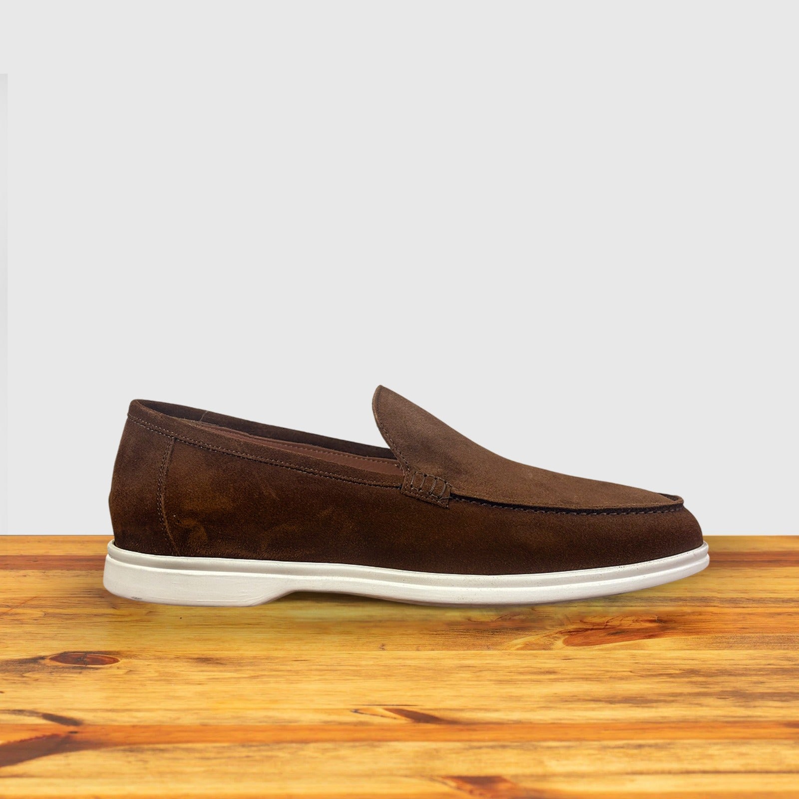 A Brick suede loafer shoes, displayed on a wooden surface.