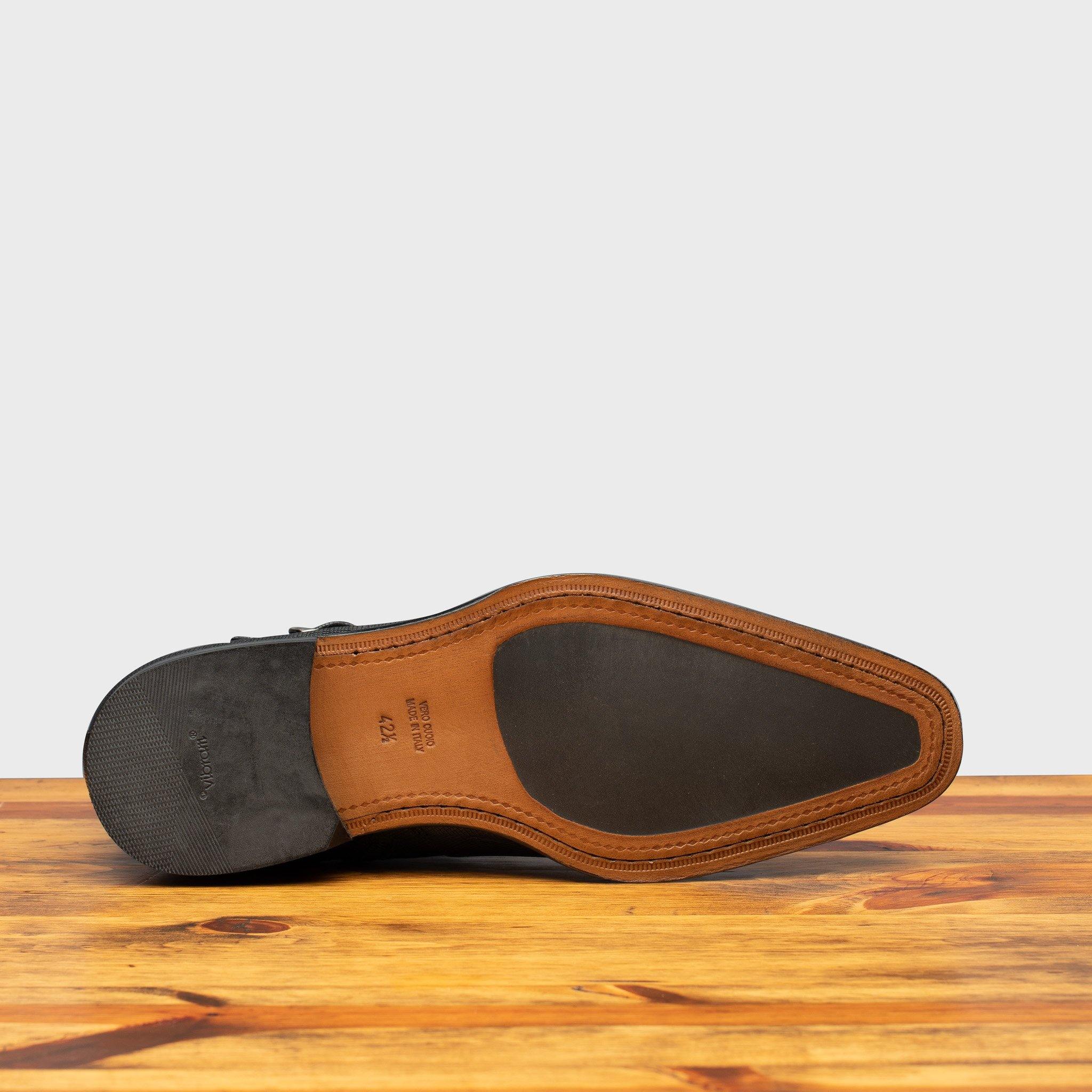 Injected Rubber Insole of the 1221 Calzoleria Toscana Saffiano Leather  Black Ankle Zip Boot on top of a wooden table