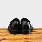 Back profile of the 2361 Calzoleria Toscana Black Cayenne Calf Cap Toe on top of a wooden table