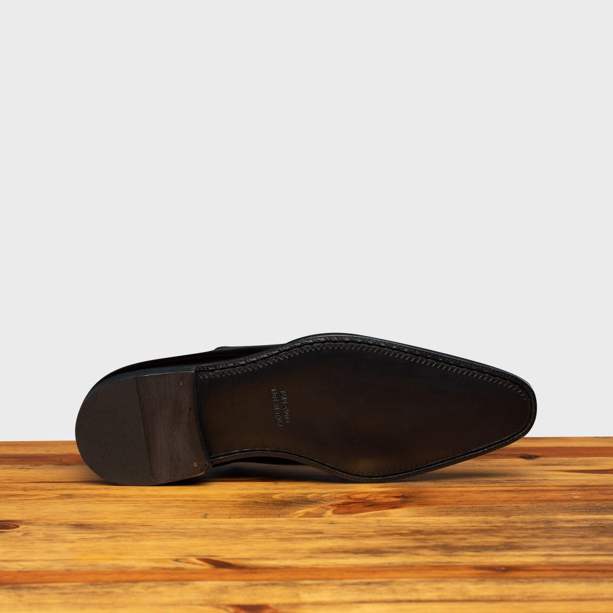 Full leather outsole of 4870 Calzoleria Toscana Burgundy David Wholecut on top of a wooden table