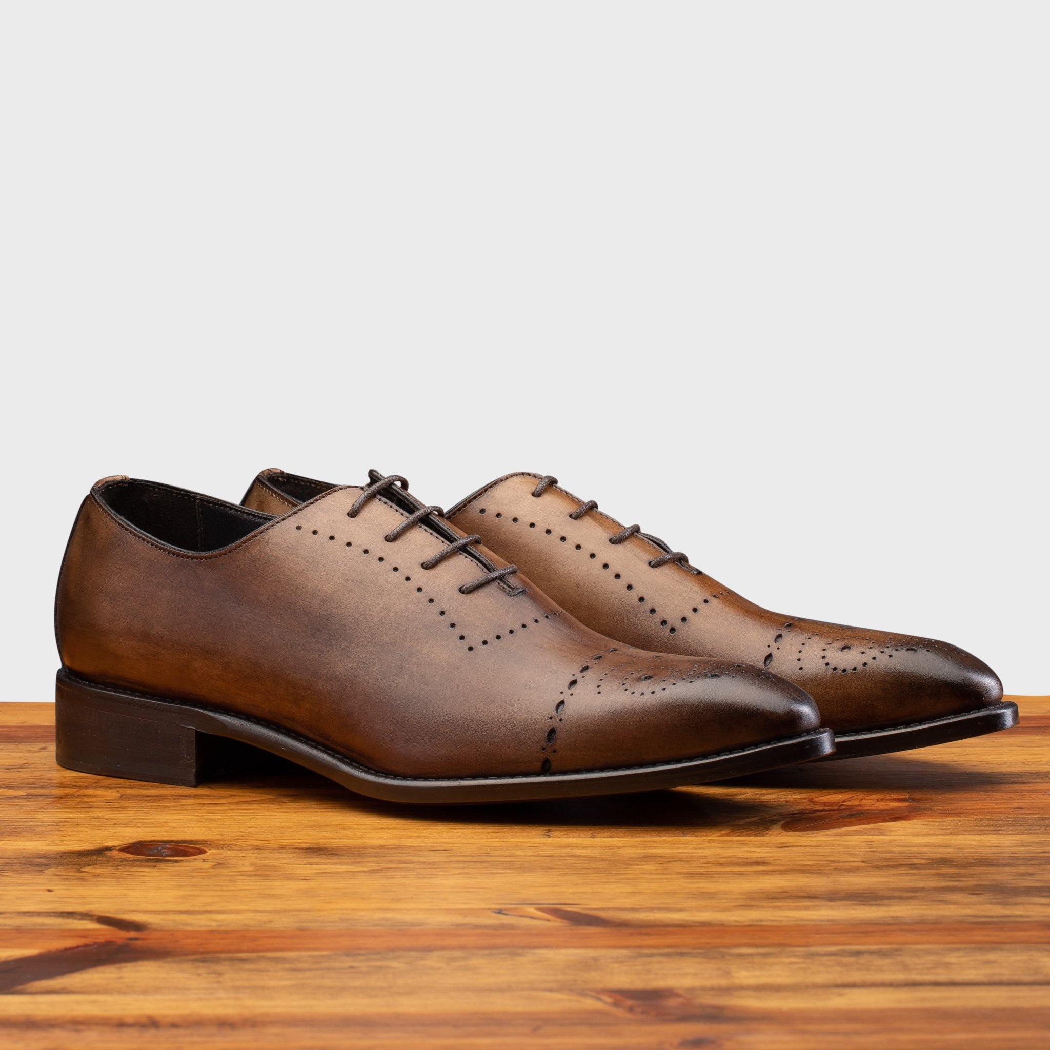 Pair of 5246 Calzoleria Toscana Cerris Wholecut Lace-up on top of a wooden table