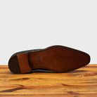 Full leather outsole of 5373 Calzoleria Toscana Black Woven Lace-Up on top of a wooden table