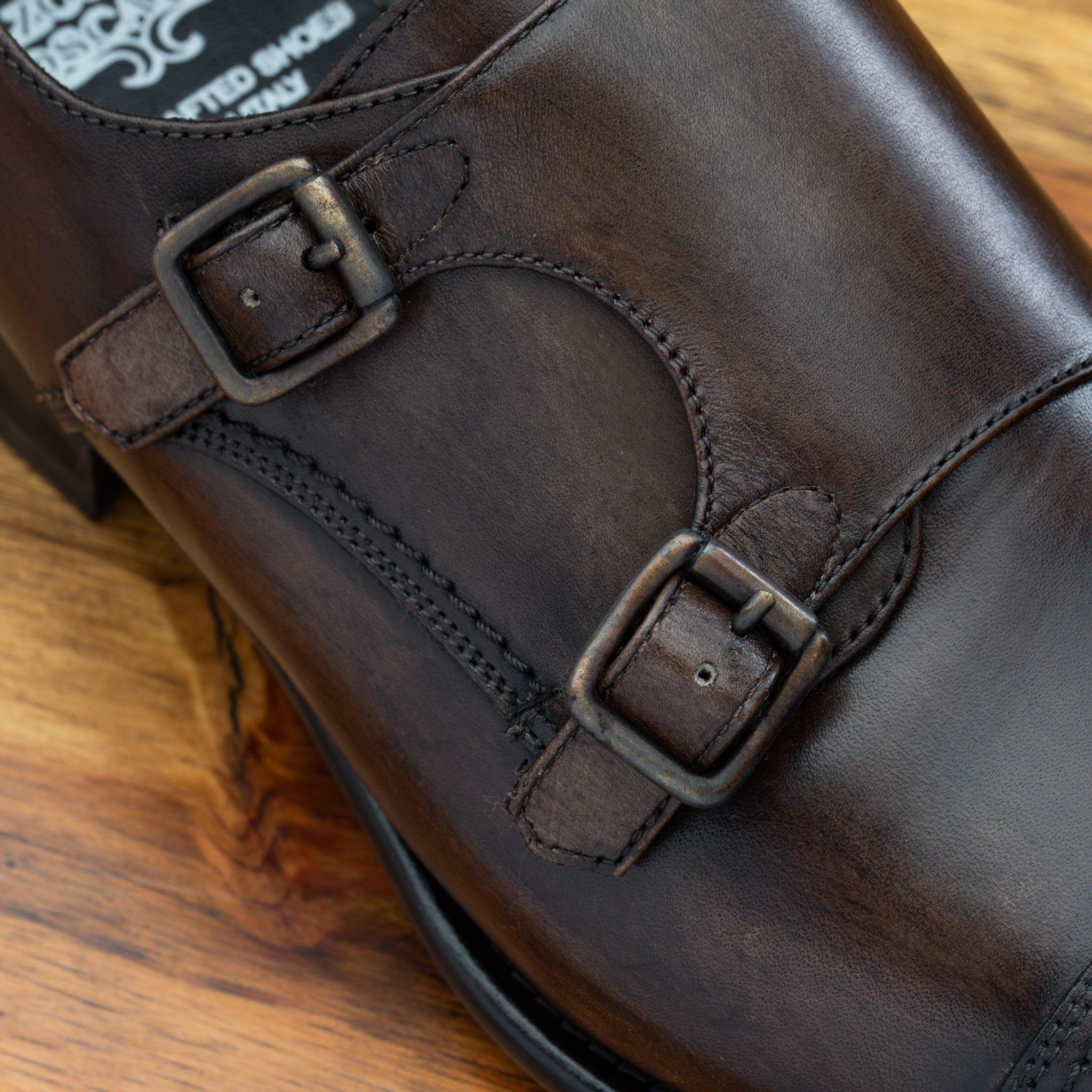 A Moor monk strap cap toe shoe with double straps, displayed on a wooden surface.