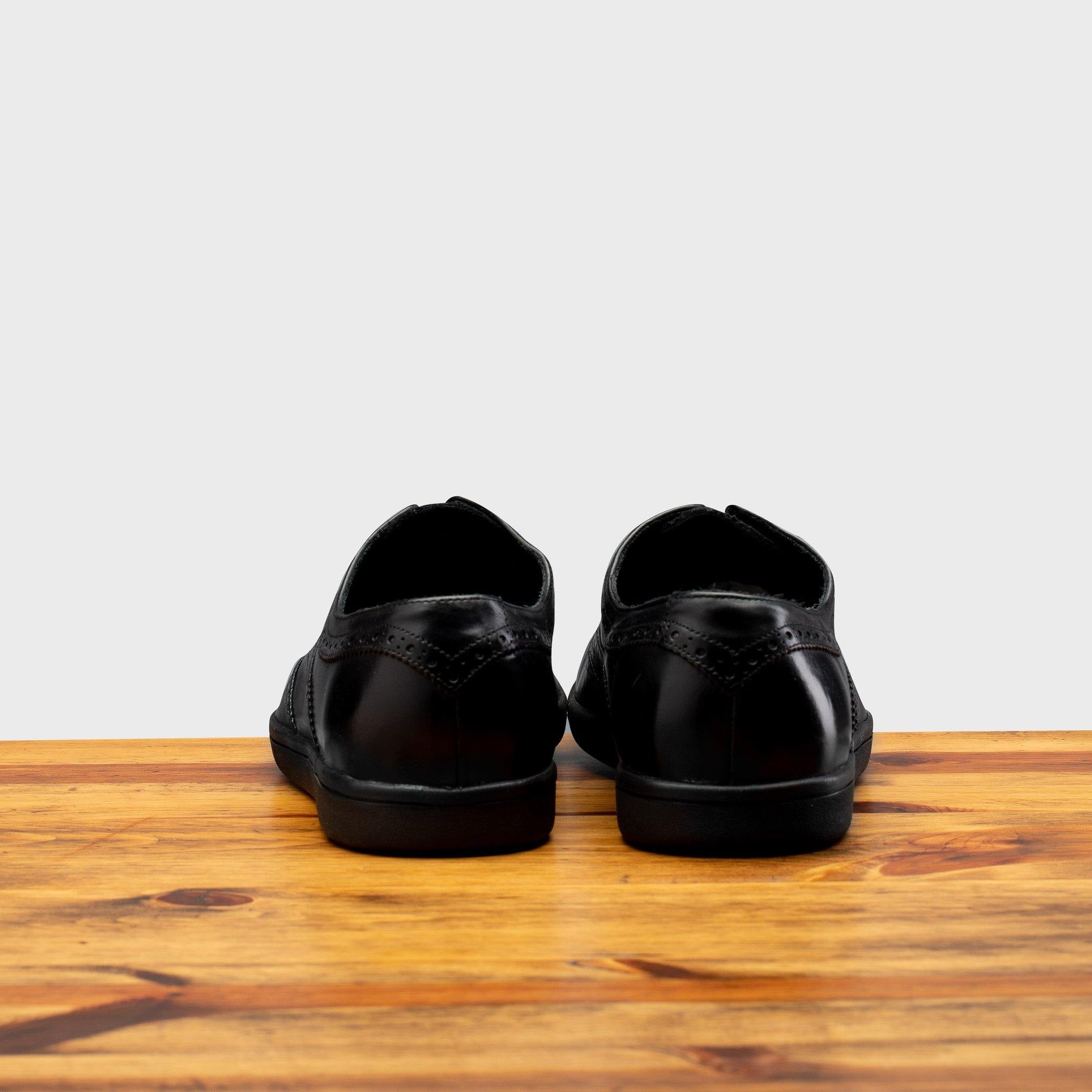 Back profile of 7839 Calzoleria Toscana Black Elba Slip-On on top of a wooden table
