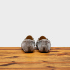 Back profile of 8976 Calzoleria Toscana Women's Light Gray Suede Driver on top of a wooden table