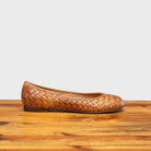 Side profile of B940 Calzoleria Toscana Brick Woven Melania Ballerina on top of a wooden table