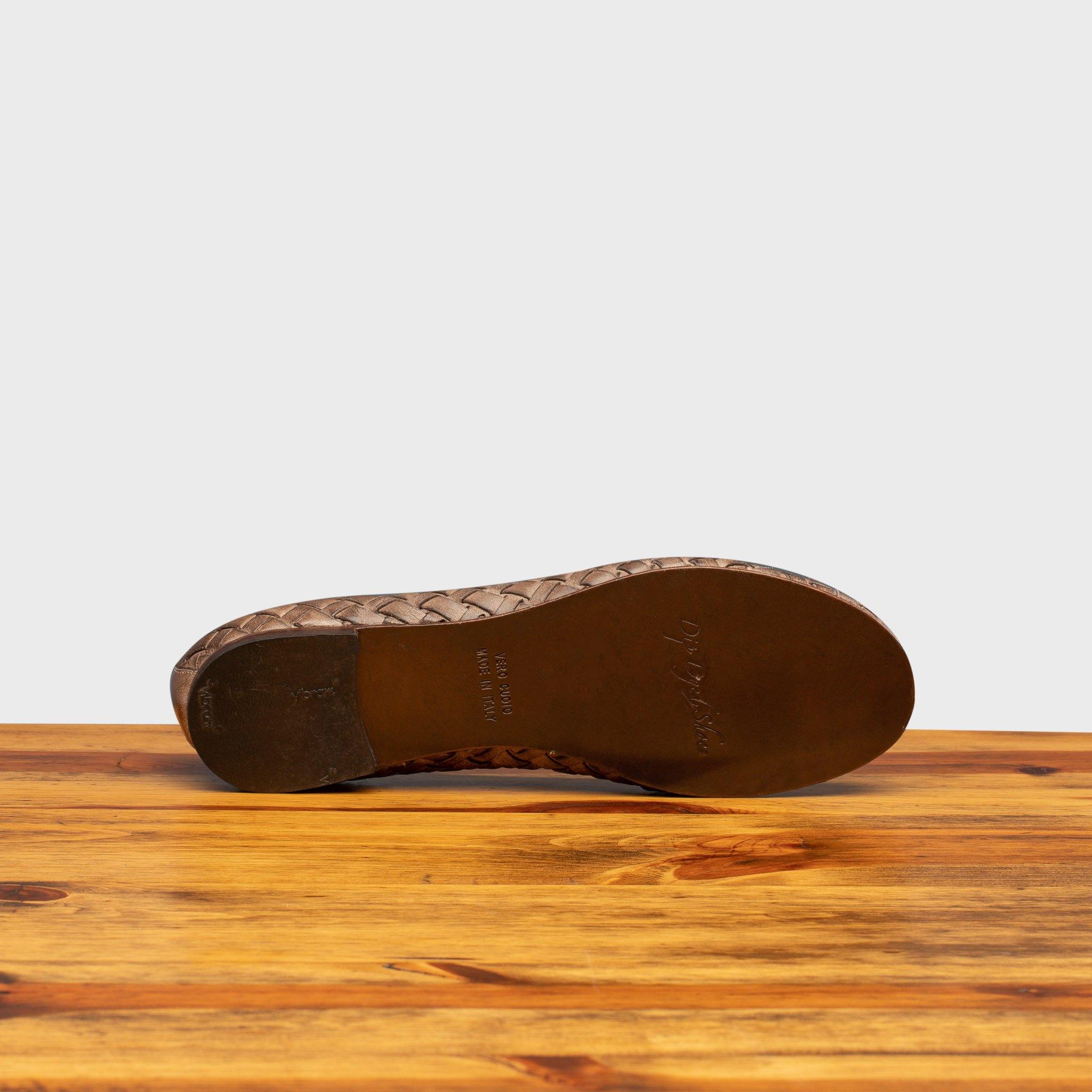 Full leather outsole of B940 Calzoleria Toscana Taupe Woven Melania Ballerina on top of a wooden table