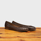 Pair of B940 Calzoleria Toscana Tobacco Woven Melania Ballerina Flat on top of a wooden table