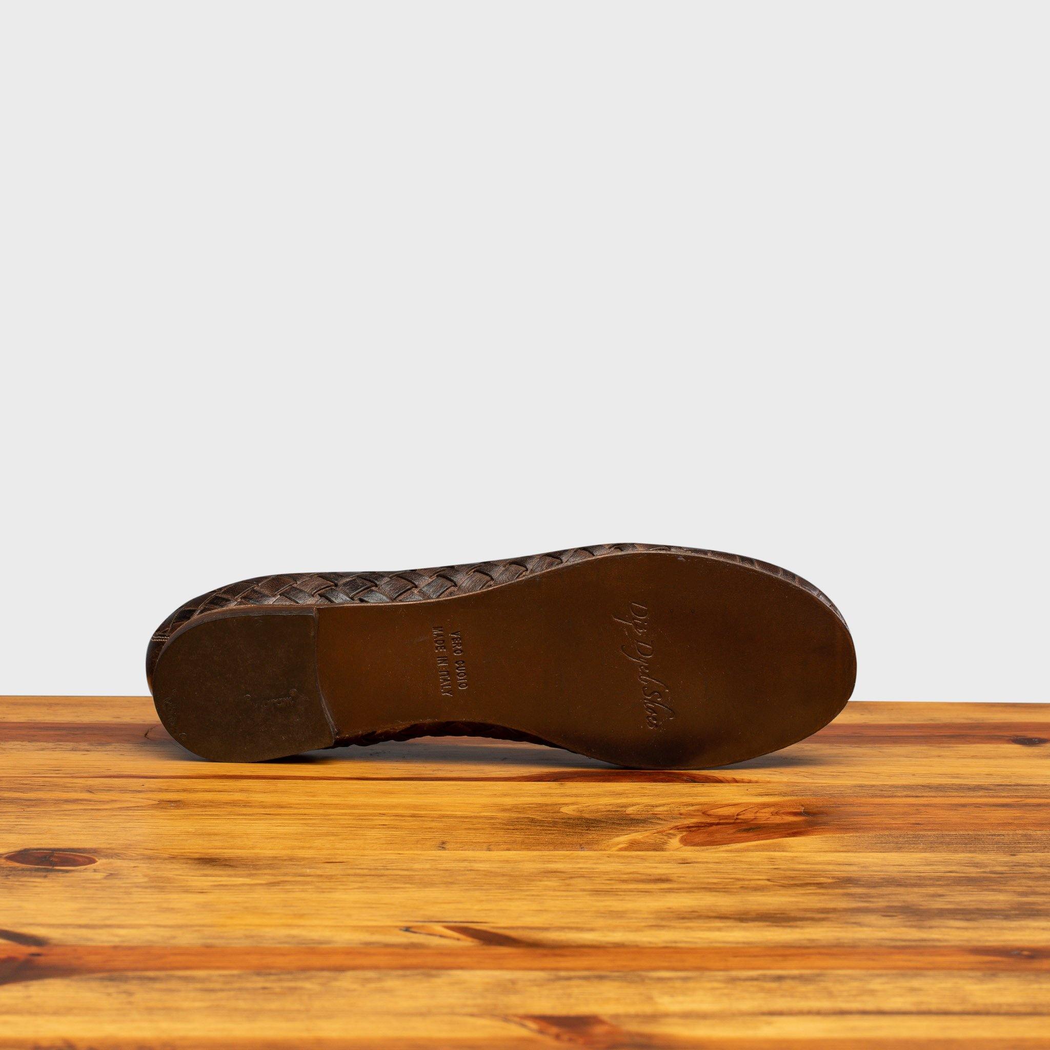 Full leather outsole of B940 Calzoleria Toscana Tobacco Woven Melania Ballerina on top of a wooden table