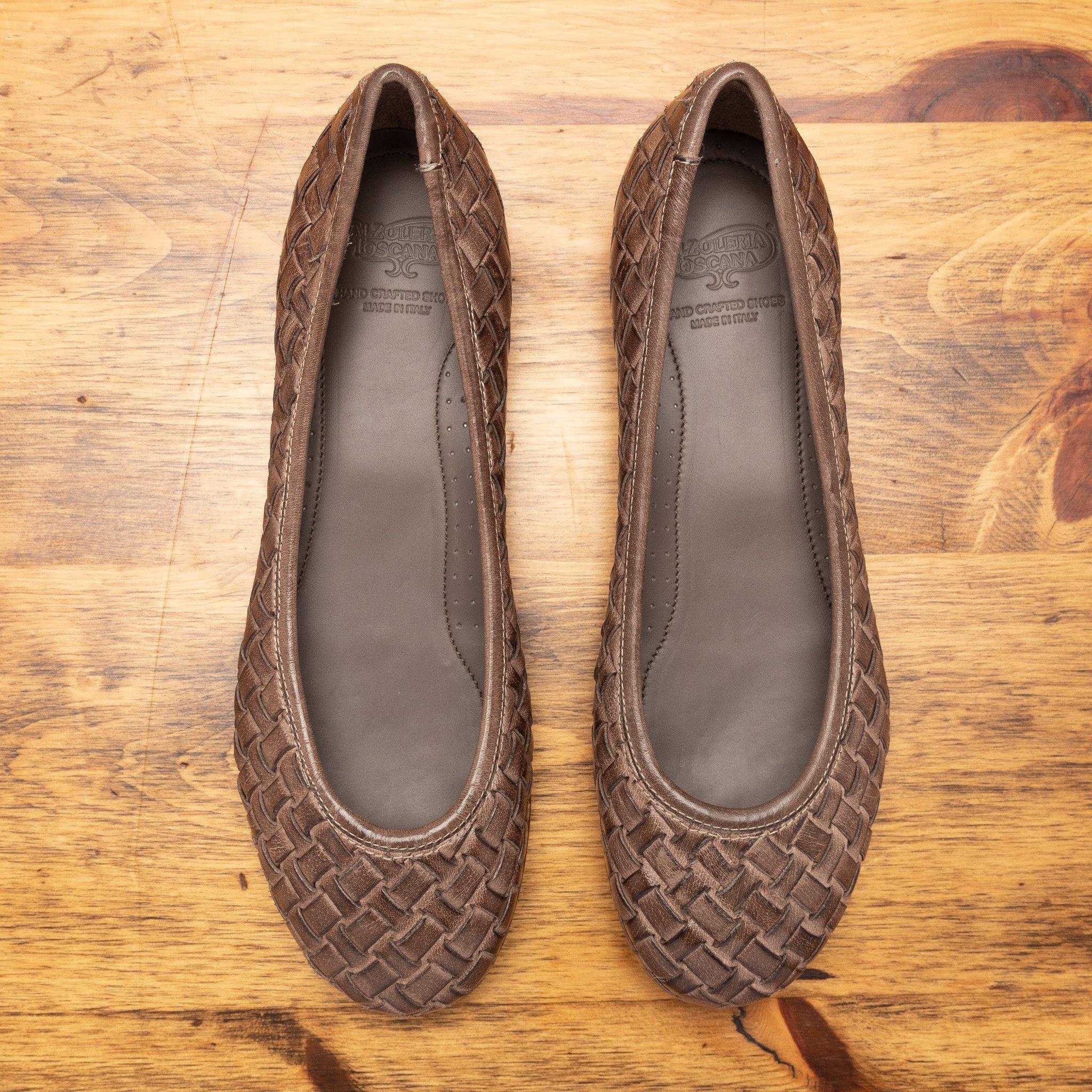 Pair of B940 Calzoleria Toscana Taupe Woven Melania Ballerina laying flat showing the branded name insole on top of a wooden table