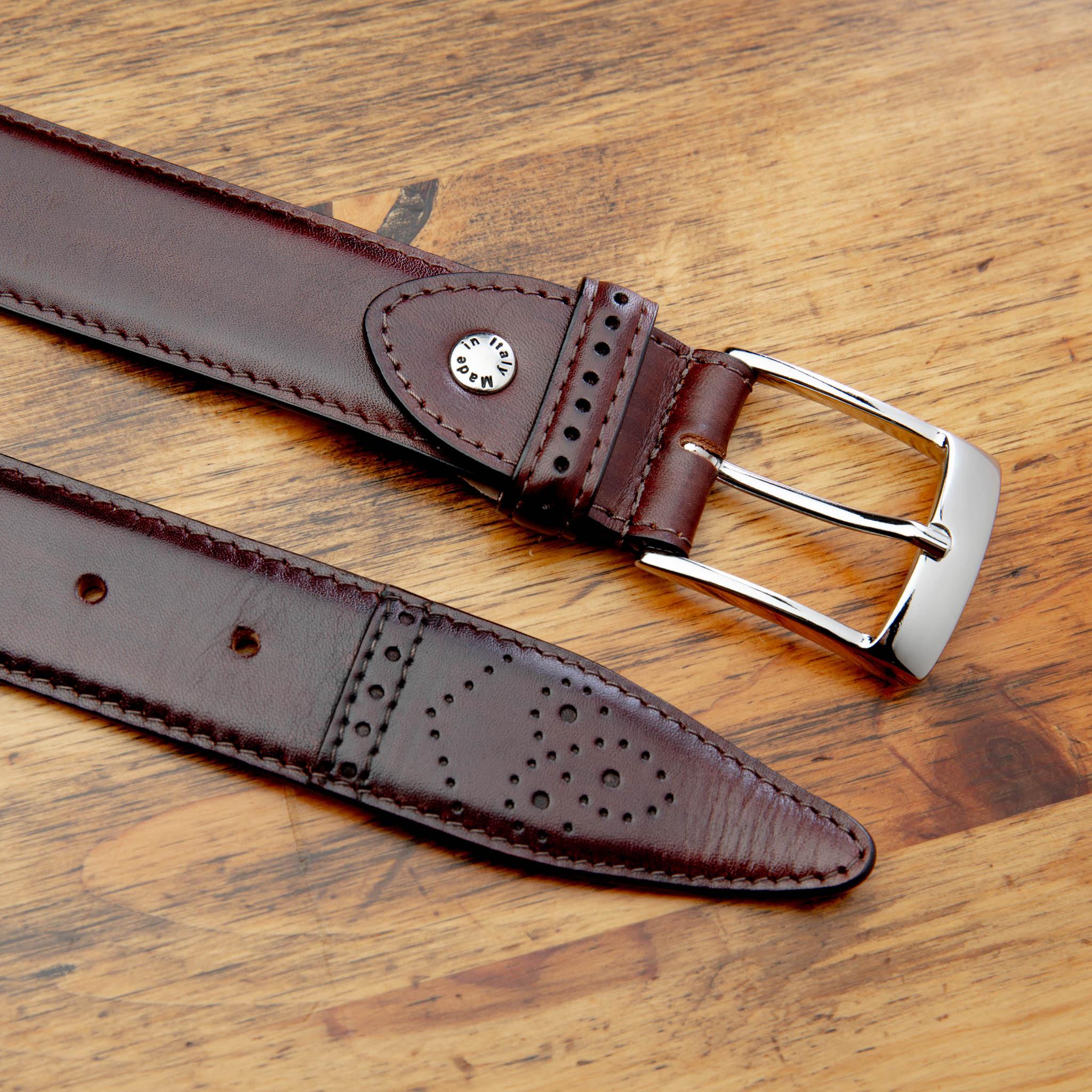 Up close picture of the silver buckle and of the medallion tip of C1732 Calzoleria Toscana Burgundy Medallion Dress Belt