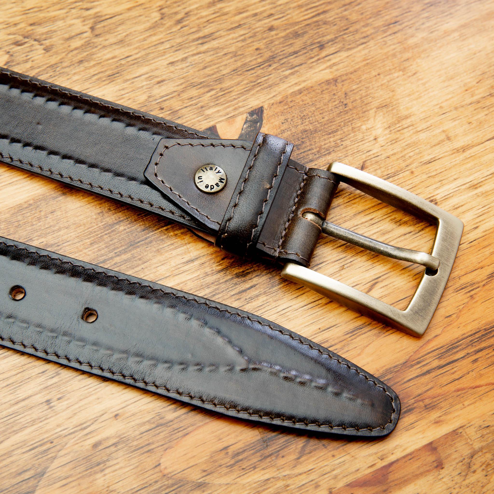 Up close picture of the gold buckle of C2216 Calzoleria Toscana Dark Brown Inner Stitched Dress Belt on top of a wooden table