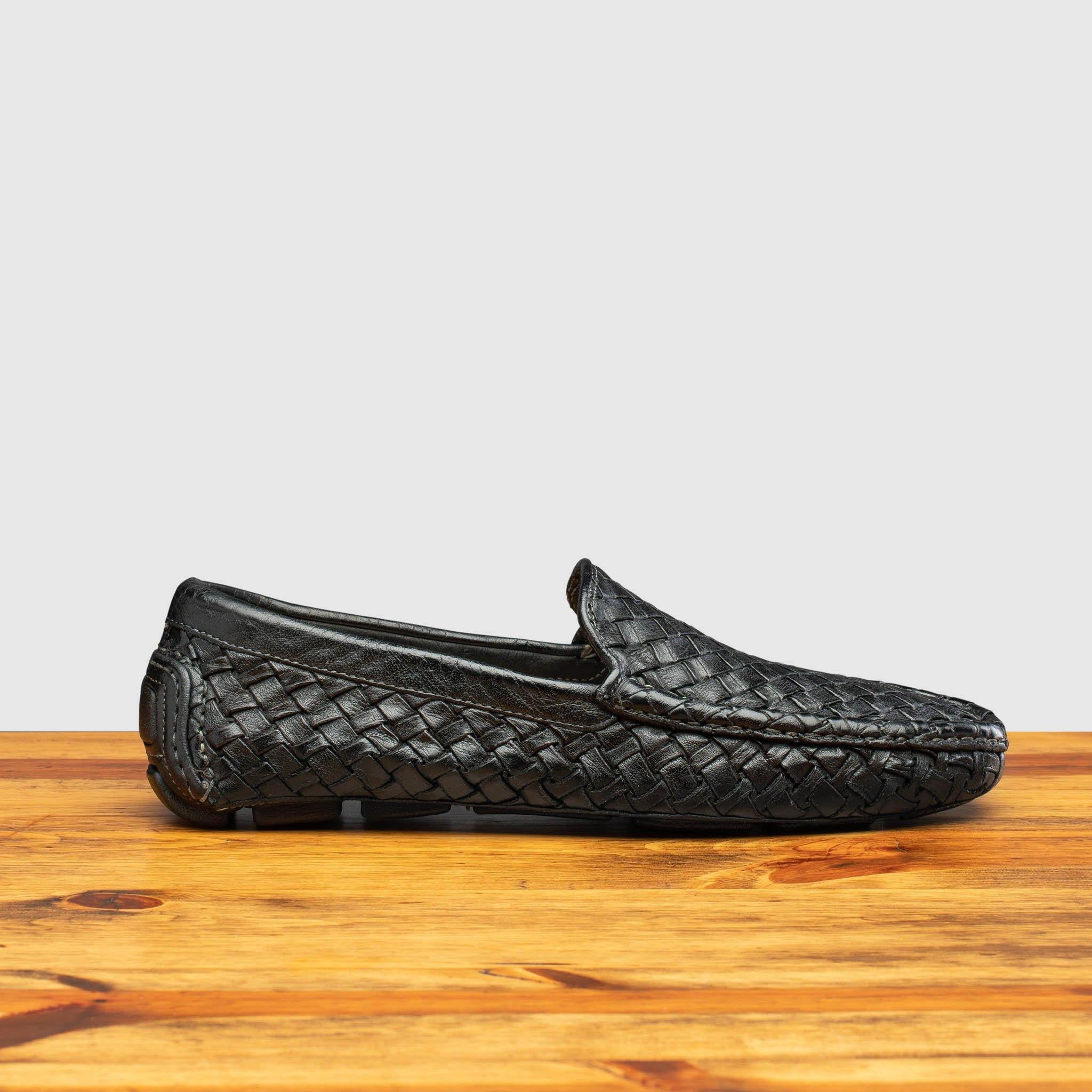 Side profile of E945 Calzoleria Toscana Black New Rendo Woven Driver on top of a wooden table