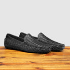 Profile of E945 Calzoleria Toscana Black New Rendo Woven Driver on top of a wooden table
