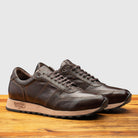 Pair of H703 Calzoleria Toscana Dark Brown Sixty-Seven Runner on top of a wooden table