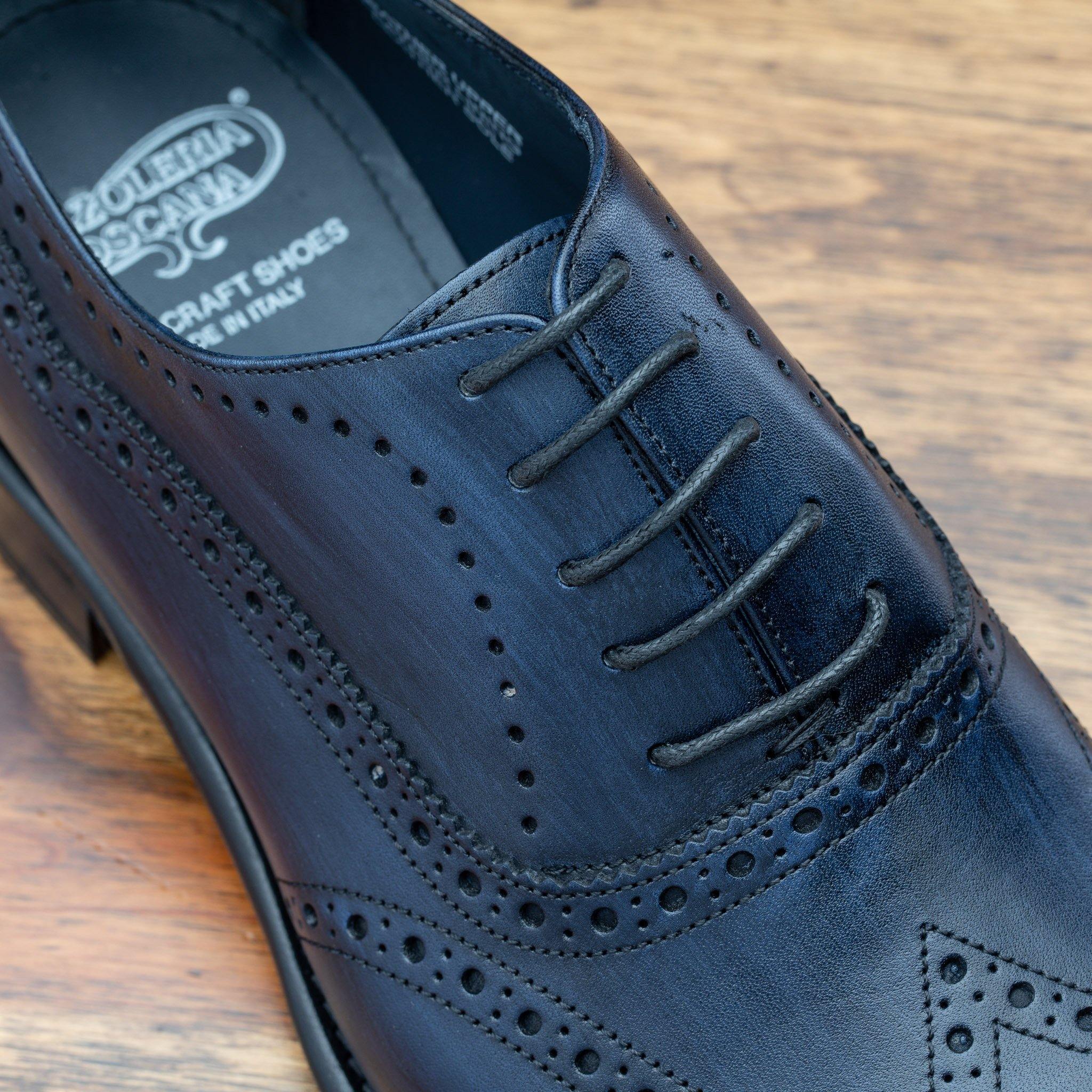 Close view of Blue leather dress shoe on a wooden surface