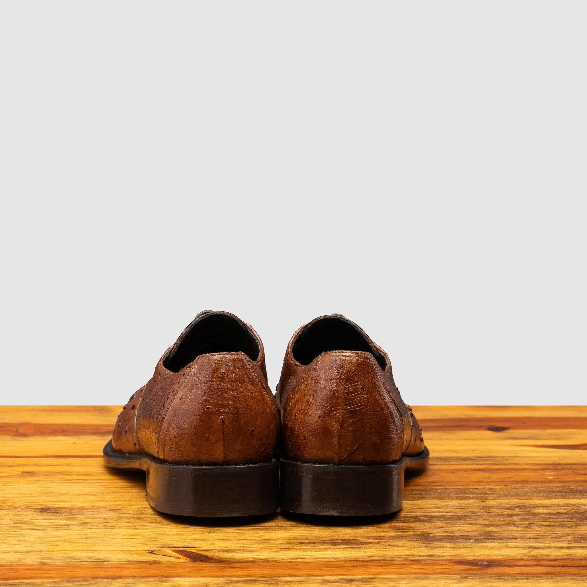 Back profile of H777 Calzoleria Toscana Cognac Ostrich Cap Toe on top of a wooden table