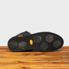 Full Vibram Arctic Grip Rubber Outsole of H867 Calzoleria Toscana Stone Dip-Dyed Hiking Sneaker on top of a wooden table