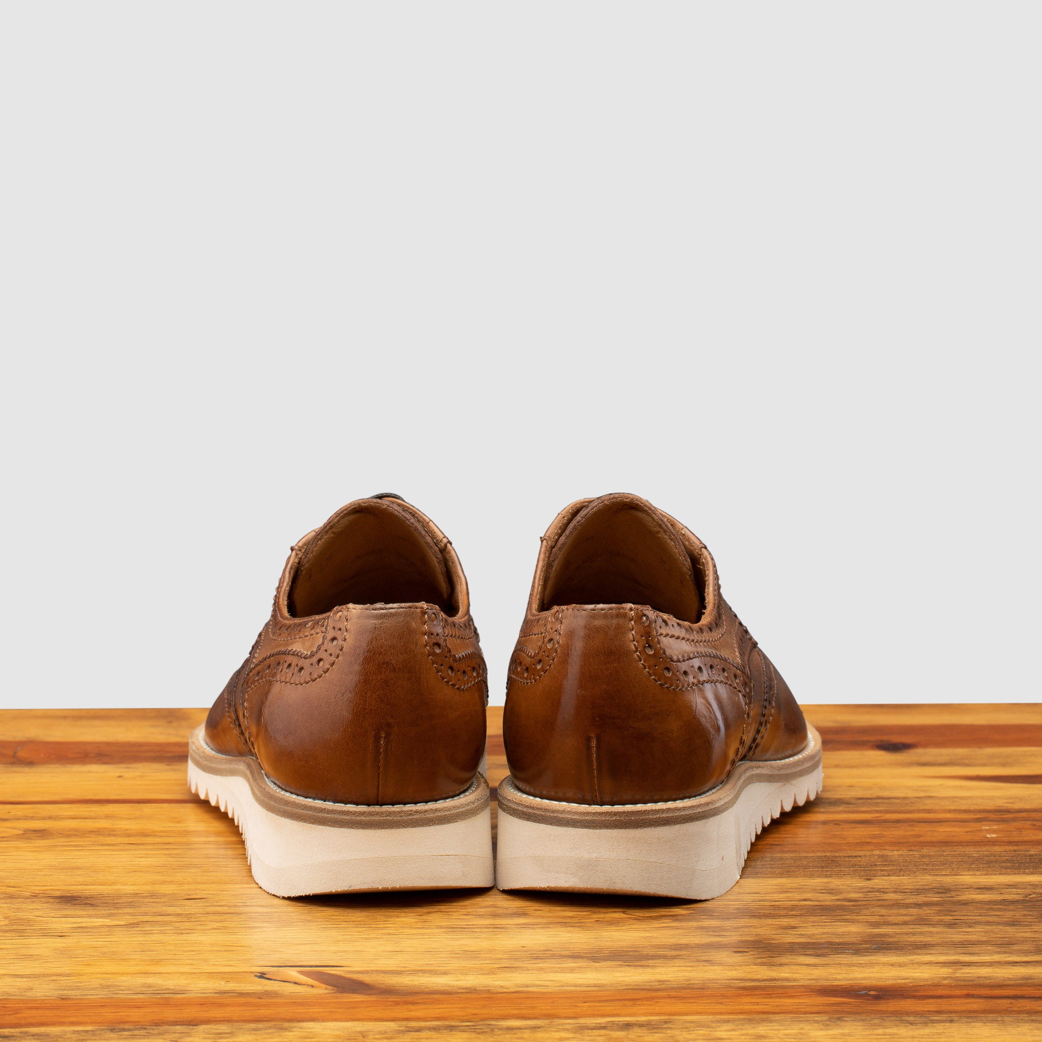 Back profile of Q399 Calzoleria Toscana Agos Wingtip Blucher on top of a wooden table
