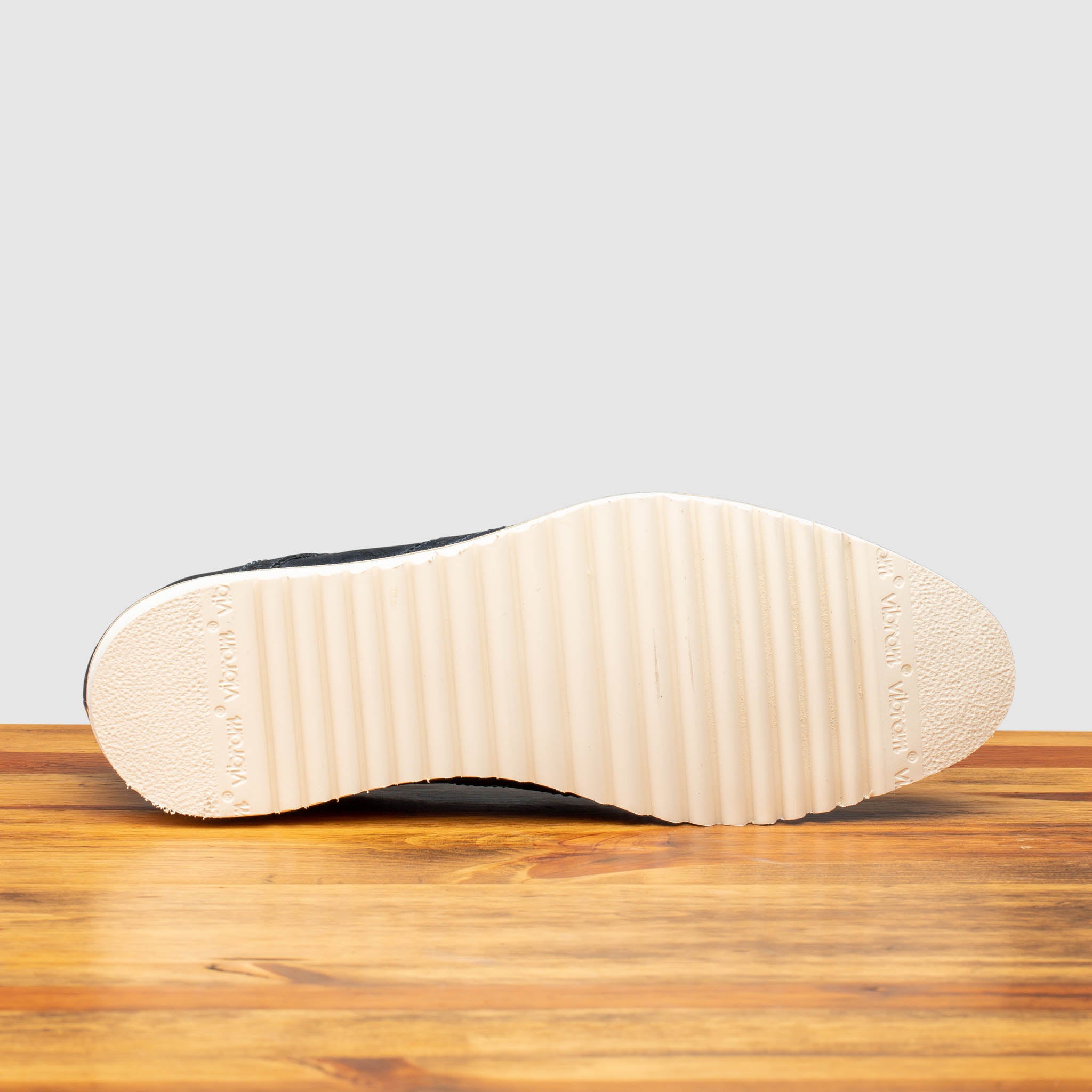 Full White Vibram Outsole of Q399 Calzoleria Toscana Blue Agos Wingtip Blucher on top of a wooden table