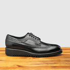 Side profile of Q400 Calzoleria Toscana Black Ago Blucher on top of a wooden table