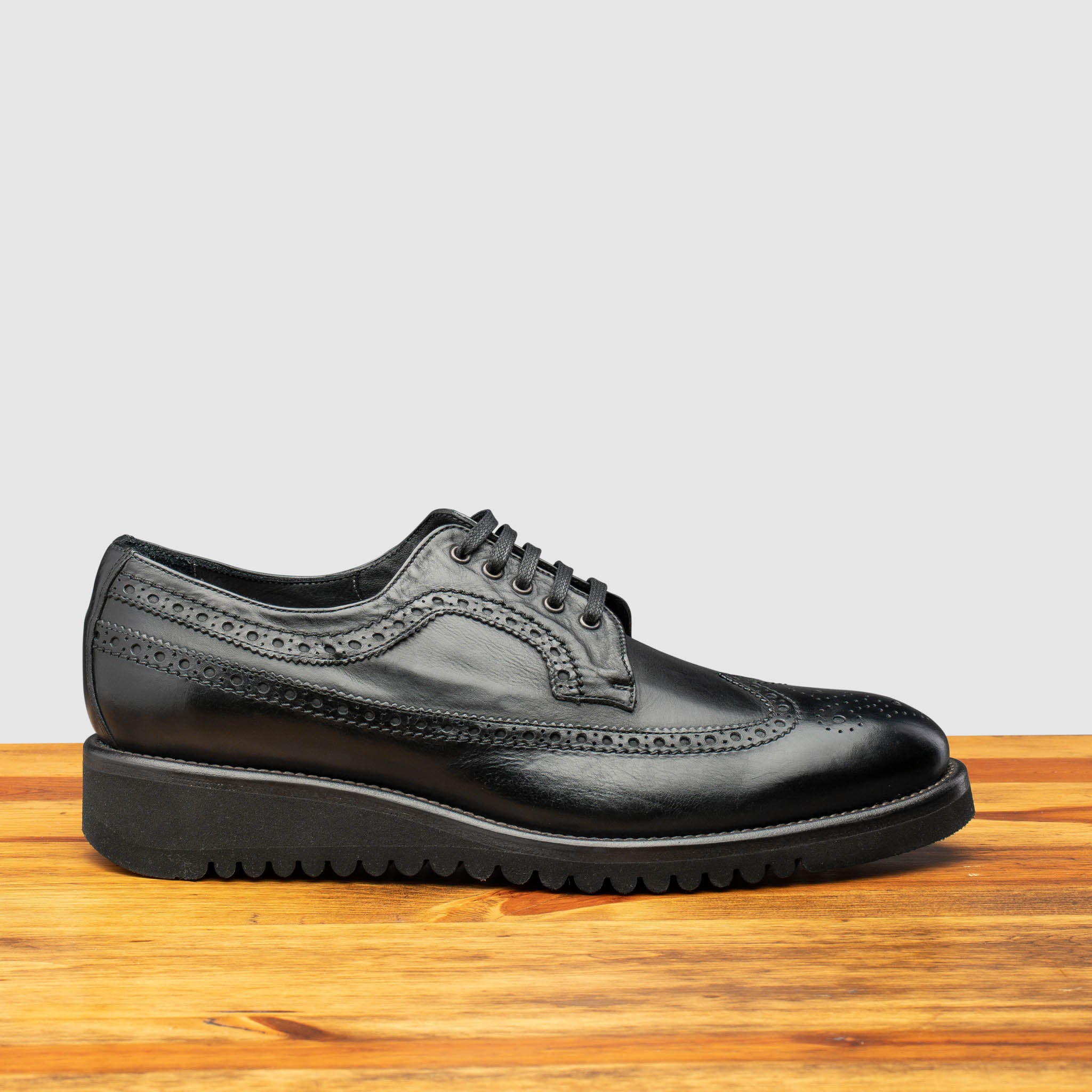 Side profile of Q400 Calzoleria Toscana Black Ago Blucher on top of a wooden table