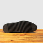 Full Rubber Vibram Outsole of Q400 Calzoleria Toscana Black Agos Blucher on top of a wooden table
