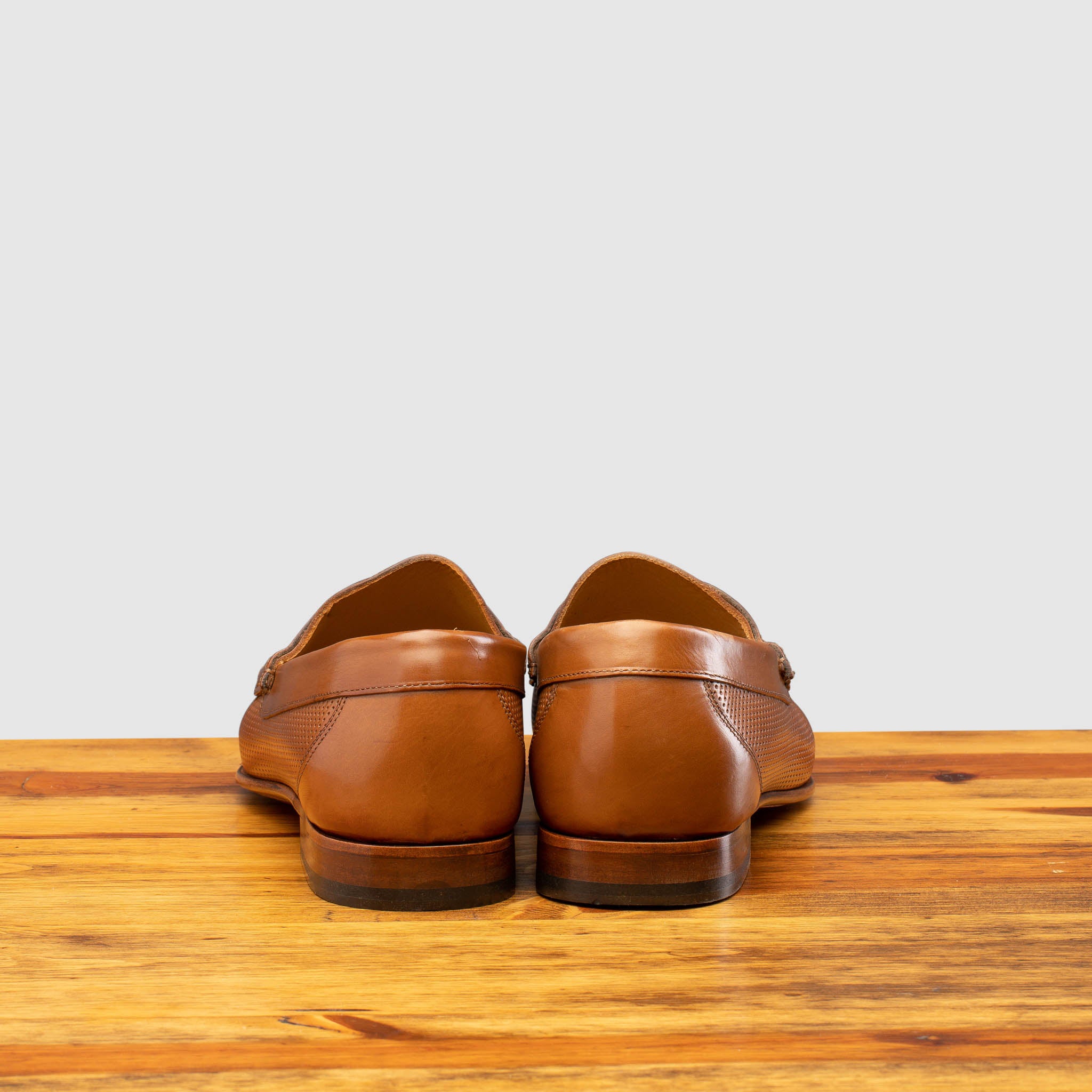 Back profile of Q479-M Calzoleria Toscana Brick Tony-M Loafer on top of a wooden table