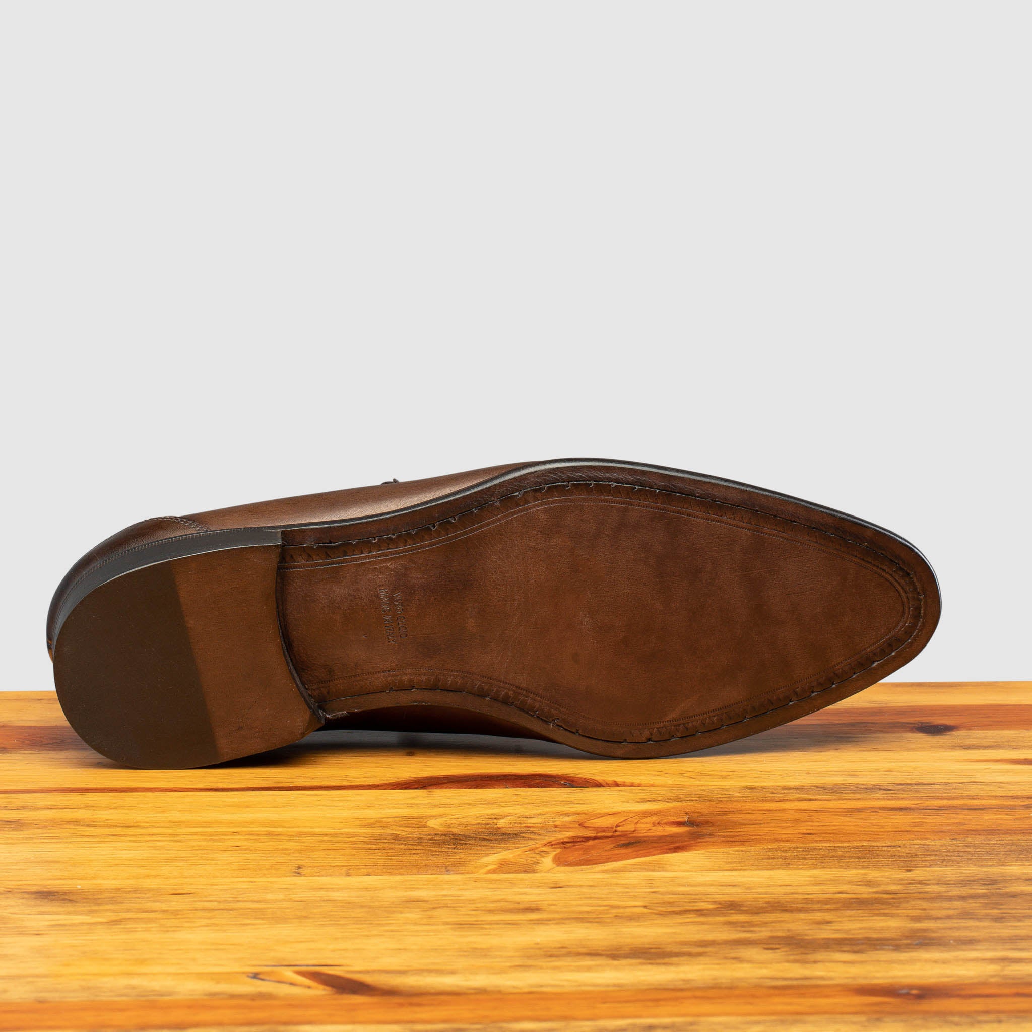 Outsole of Moor leather loafer on a wooden surface with a light gray background