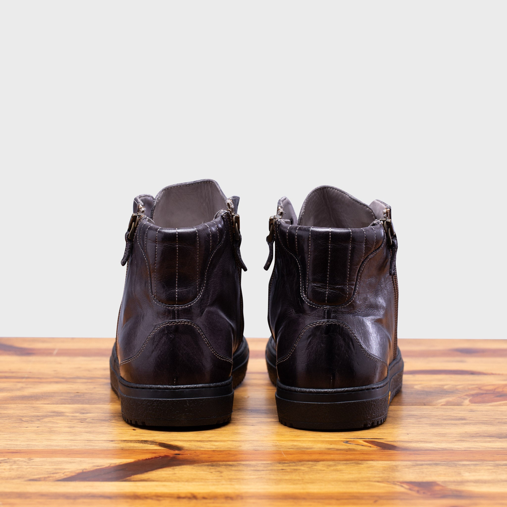 Back profile of Q555 Calzoleria Toscana Stone Dip-Dyed Buff Calf High Top on top of a wooden table