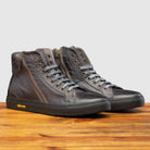 Pair of Q555 Stone Calzoleria Toscana Stone Dip-Dyed Buff Calf High Top on top of a wooden table