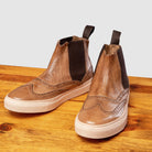 Pair of D741 Calzoleria Toscana Women's  Moor Ankle Sneaker on top of a wooden table