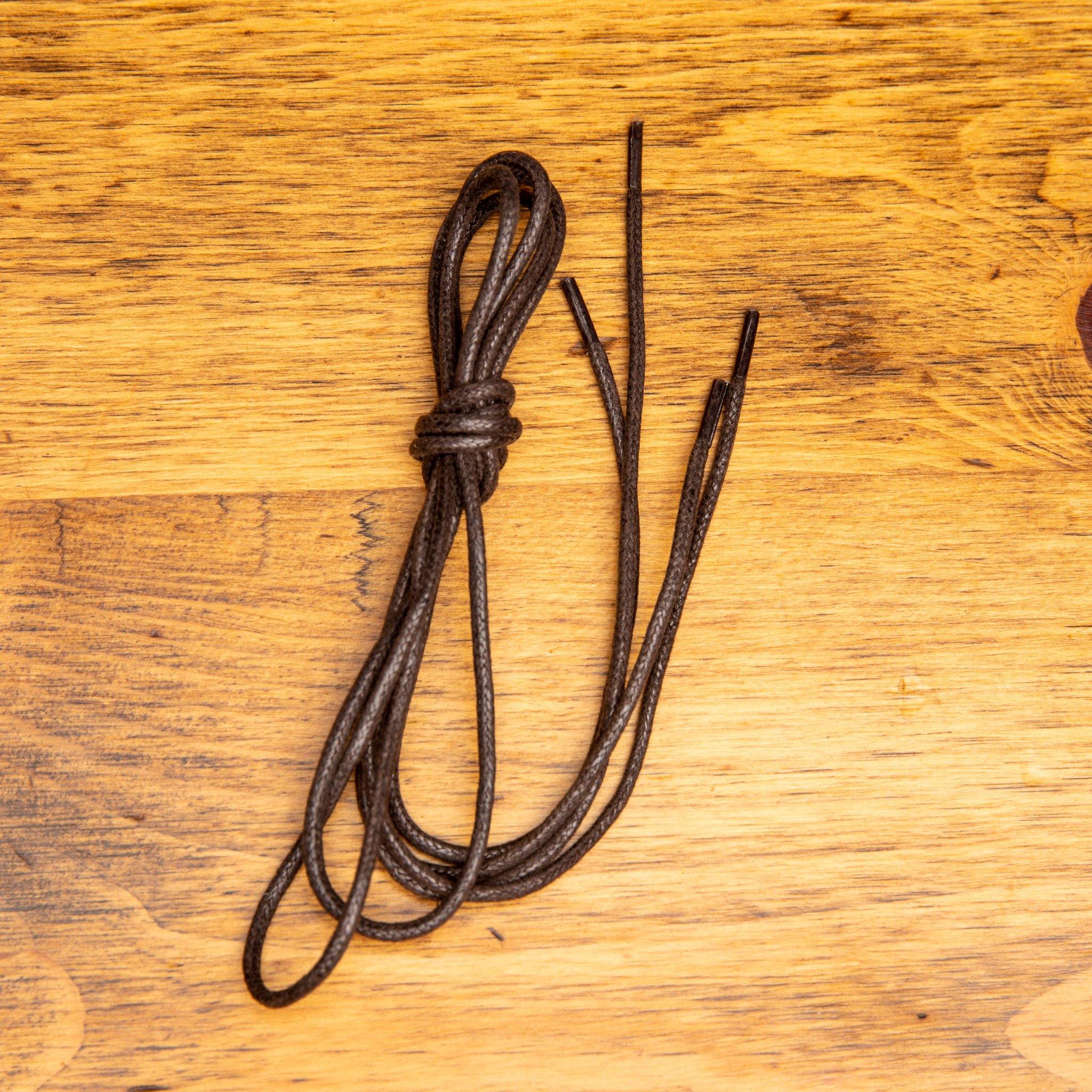 Brown Pair of Calzoleria Toscana Waxed Cotton Lace on top of a wooden table