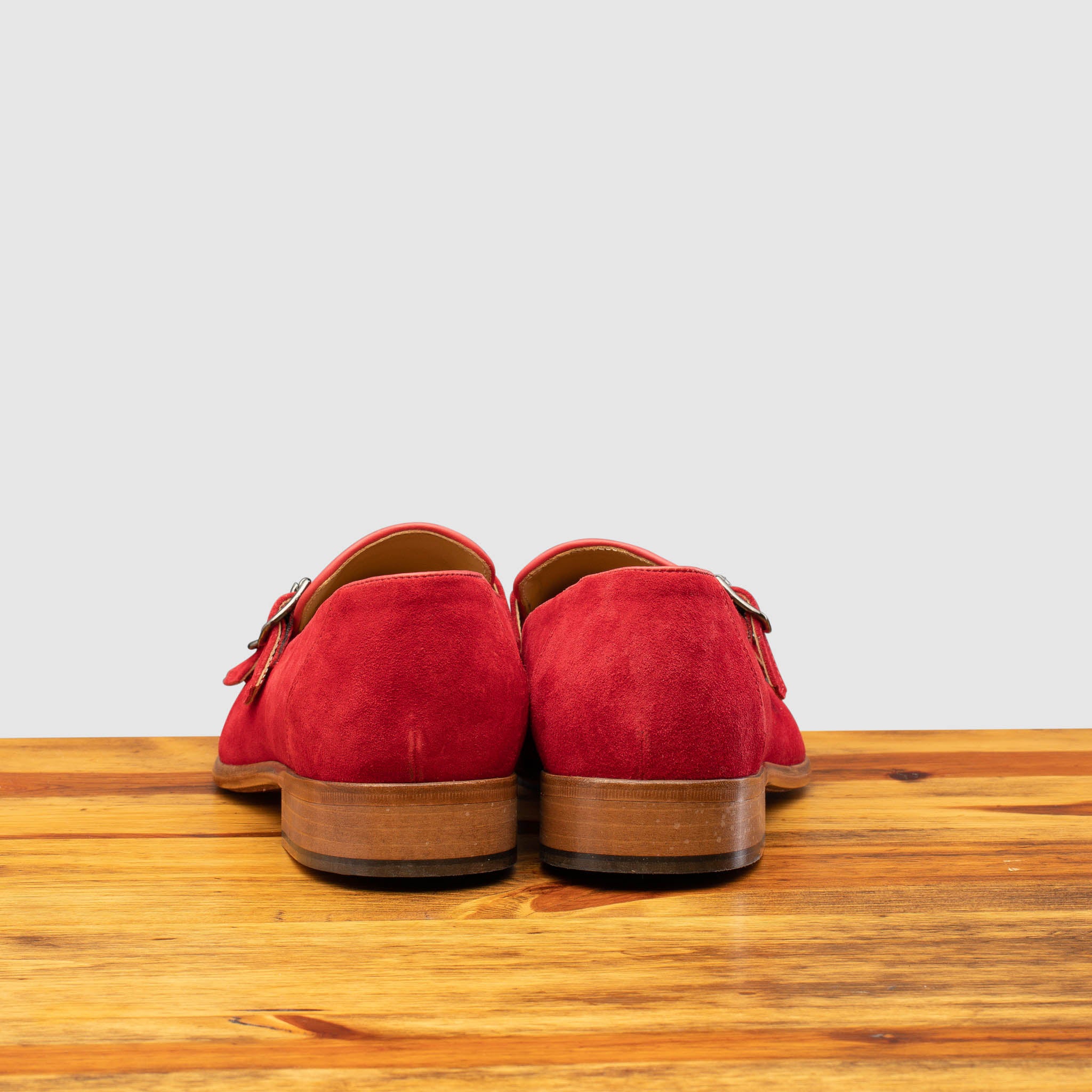 Back profile of Z893 Calzoleria Toscana Red Suede Double Strap Low Vamp Slip-On on top of a wooden table