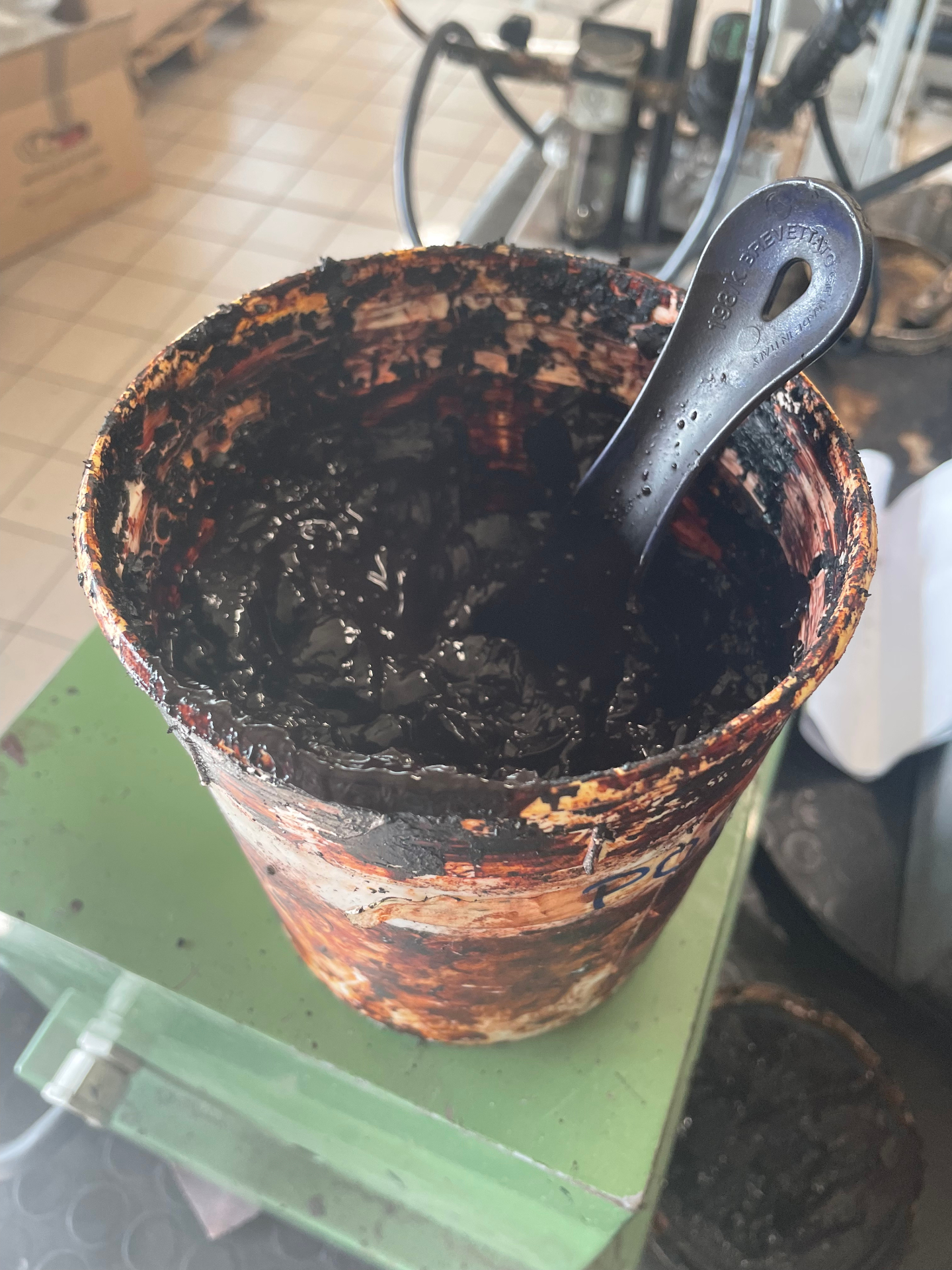 An artisan's hands immersed in a bucket of organic, vegetable-based dye used to color Calzoleria Toscana leather