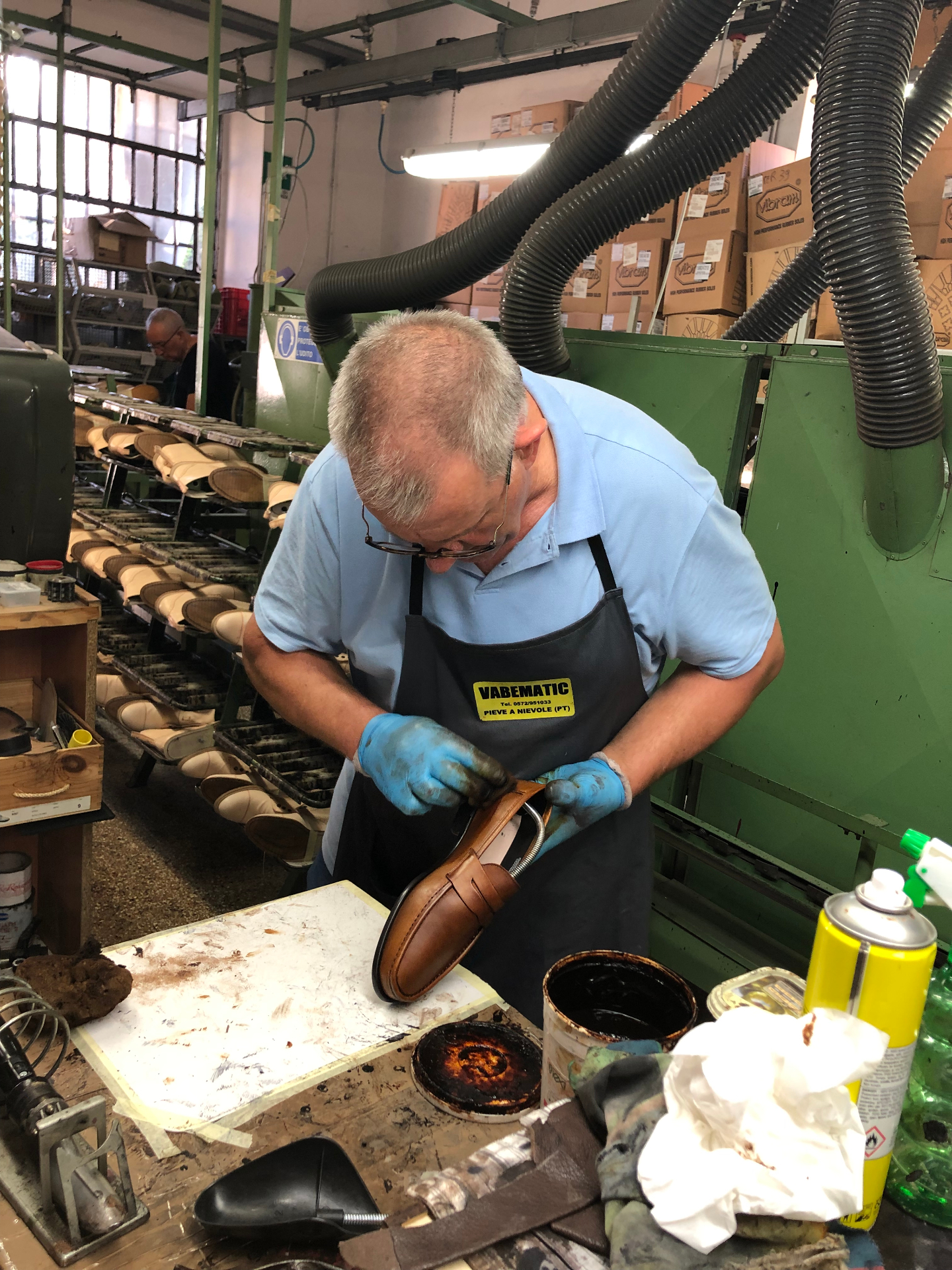 A master Tuscan artisan hand-painting a tan leather Santor loafer with vegetable-based dye