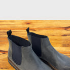 Pair of Stone leather Chelsea boots on a wooden surface