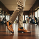 Person wearing brown shoes and beige pants in a golf course clubhouse.
