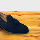 Blue loafer with a tassel on a wooden surface