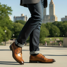 Person wearing Chestnut dress shoes with a blurred cityscape background