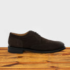 Dusty Brown suede dress shoe on a wooden surface with a light gray background