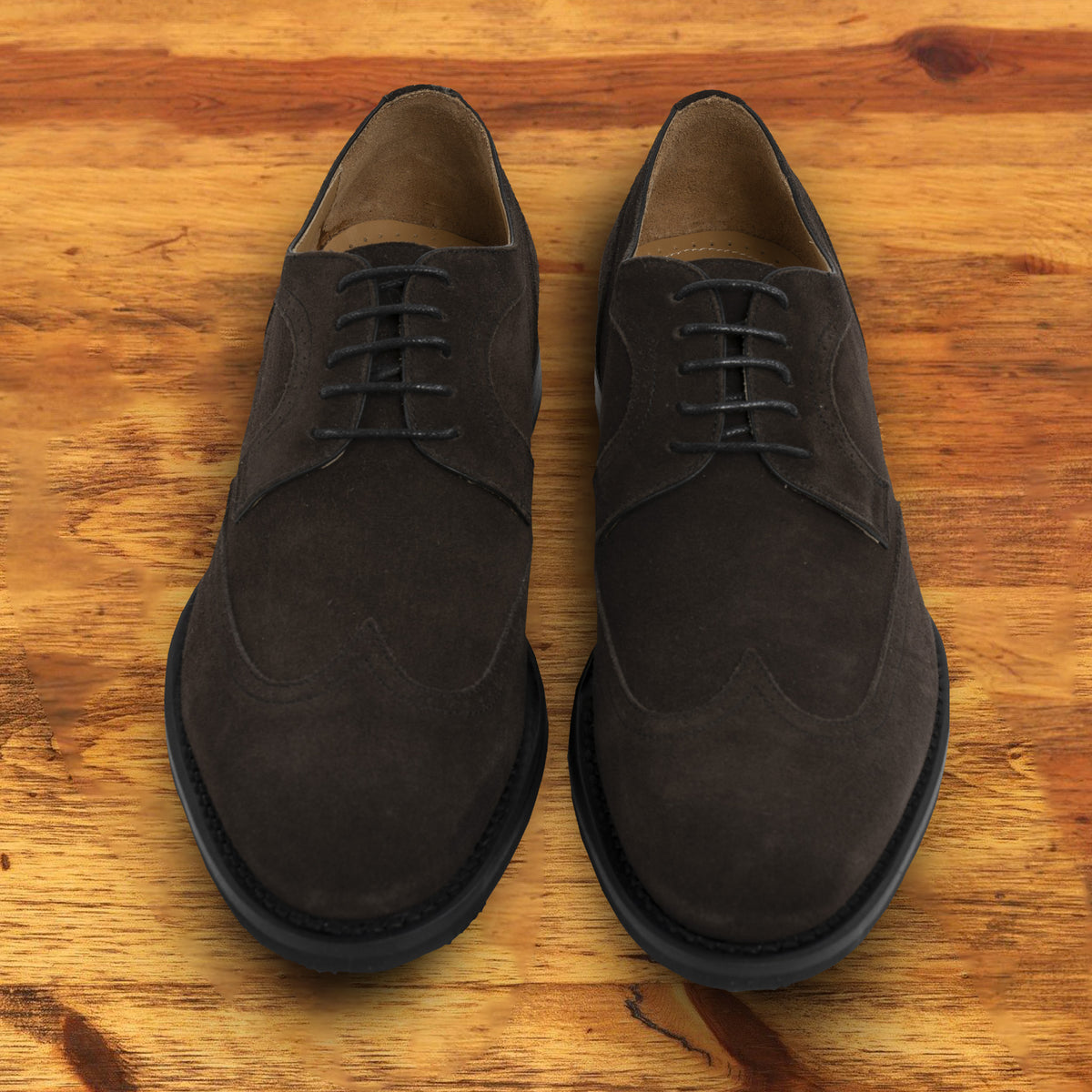 Dusty Brown suede dress shoe on a wooden surface