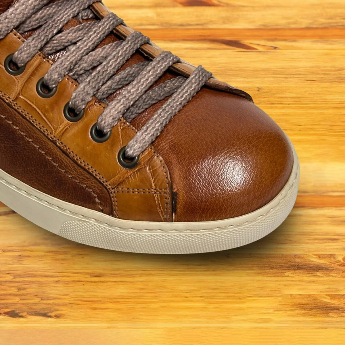 Brick leather sneaker with gray laces on a wooden surface