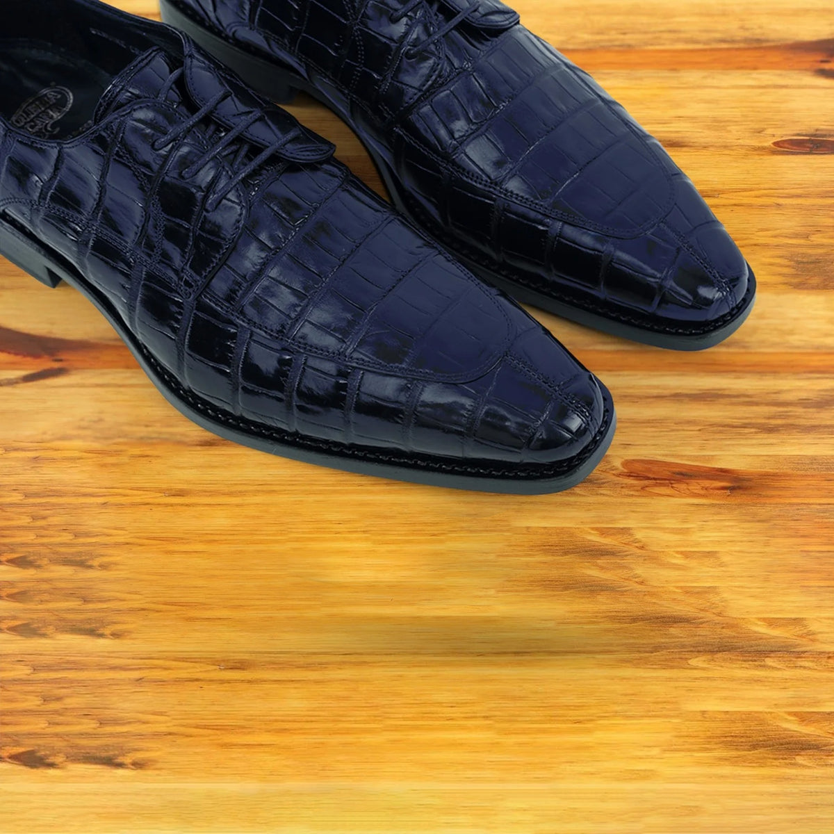 Midnight Blue crocodile shoe on a wooden surface