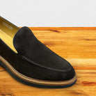 Chocolate Brown Venetian loafer with a rubber sole positioned on a wooden surface.